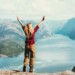 Happy traveler Woman emotional raised hands Travel adventure Lifestyle wanderlust concept vacations outdoor success walk in Norway above Lysefjord